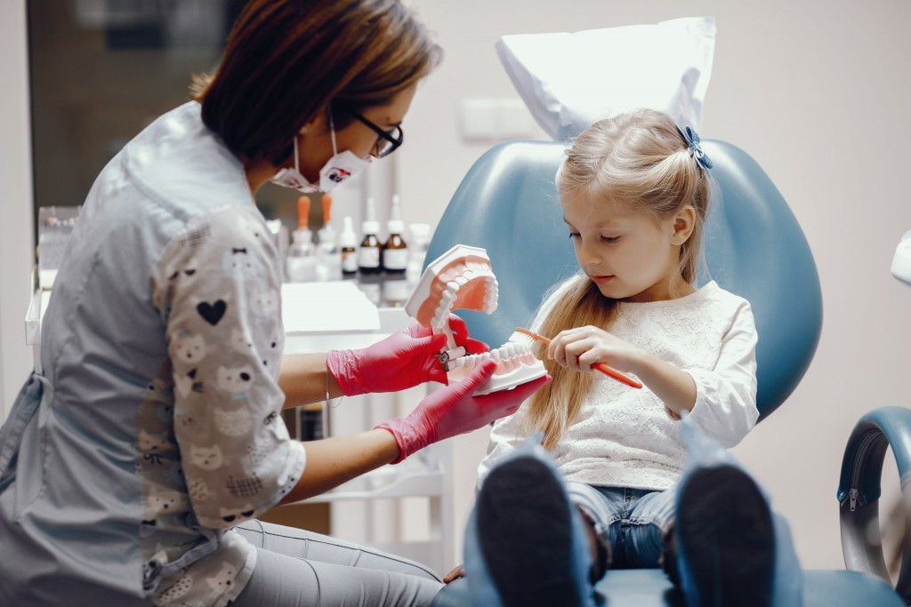 cute-little-girl-sitting-in-the-dentist-s-office-scaled